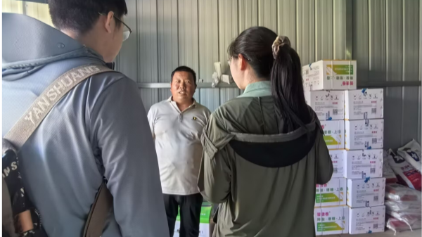 图为太阳葡萄小镇负责人刘广叔带领队员在葡萄种植区了解不同品种引种驯化情况_副本.png